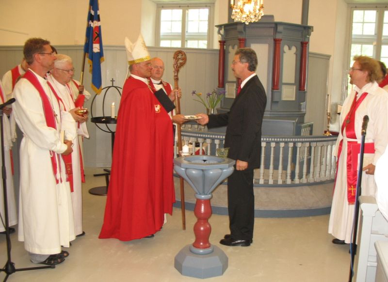 Ülo Kalm annab peapiiskop Andres Põderile üle kirikuvõtme. 