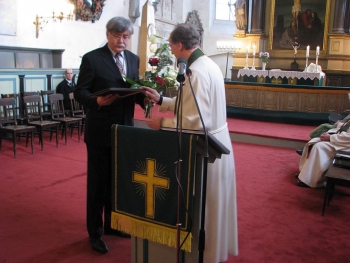Toomkoguduse kauaaegset juhatuse esimeest Raido Rüütlit õnnitleb Maarja medali puhul koguduse õpetaja Jaak Salumäe.